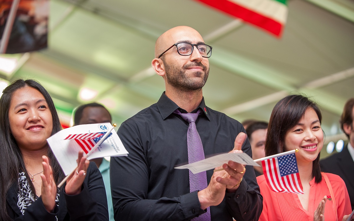 Individuals at an oath ceremony celebrate after taking more than one path to citizenship