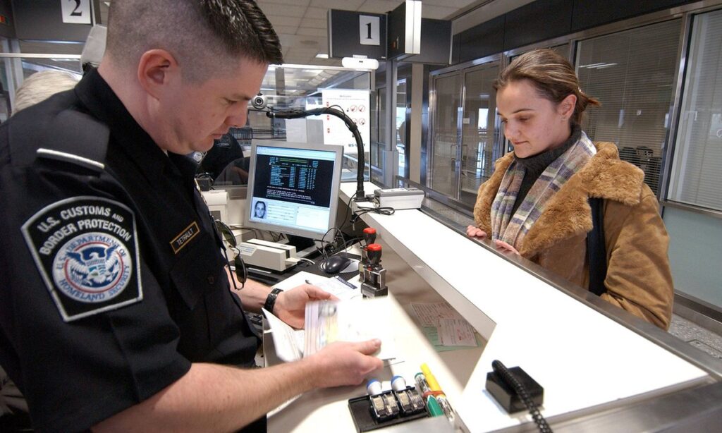 El oficial de CBP inspecciona el documento de viaje de libertad condicional anticipada