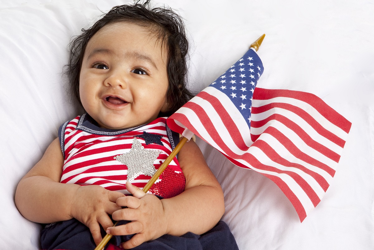 infant holding american flag after acquisition of citizenship