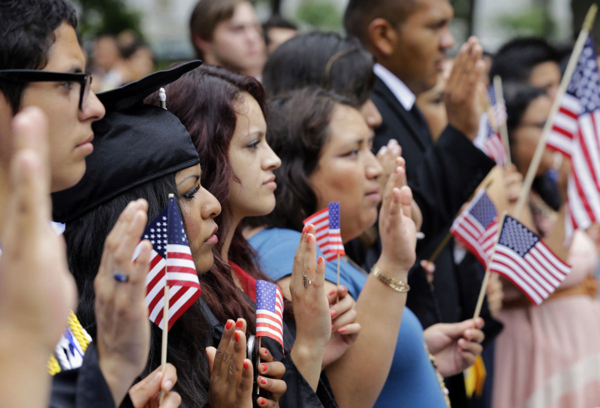 Applicants applying for citizenship participate in an oath ceremony