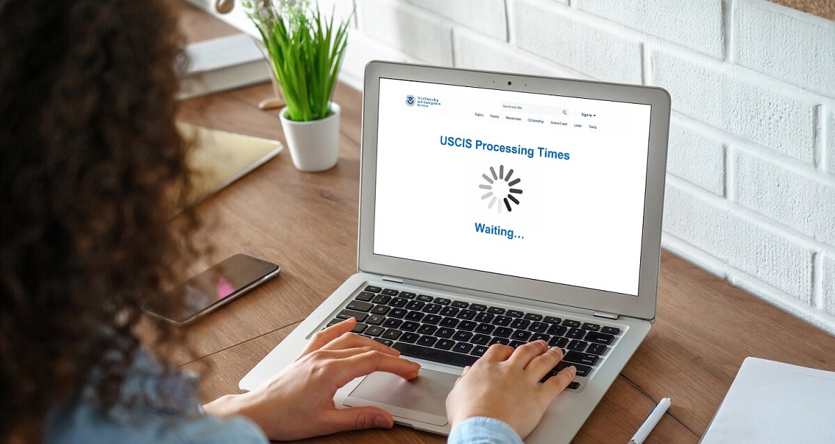 Woman waits for USCIS processing times to load on computer screen