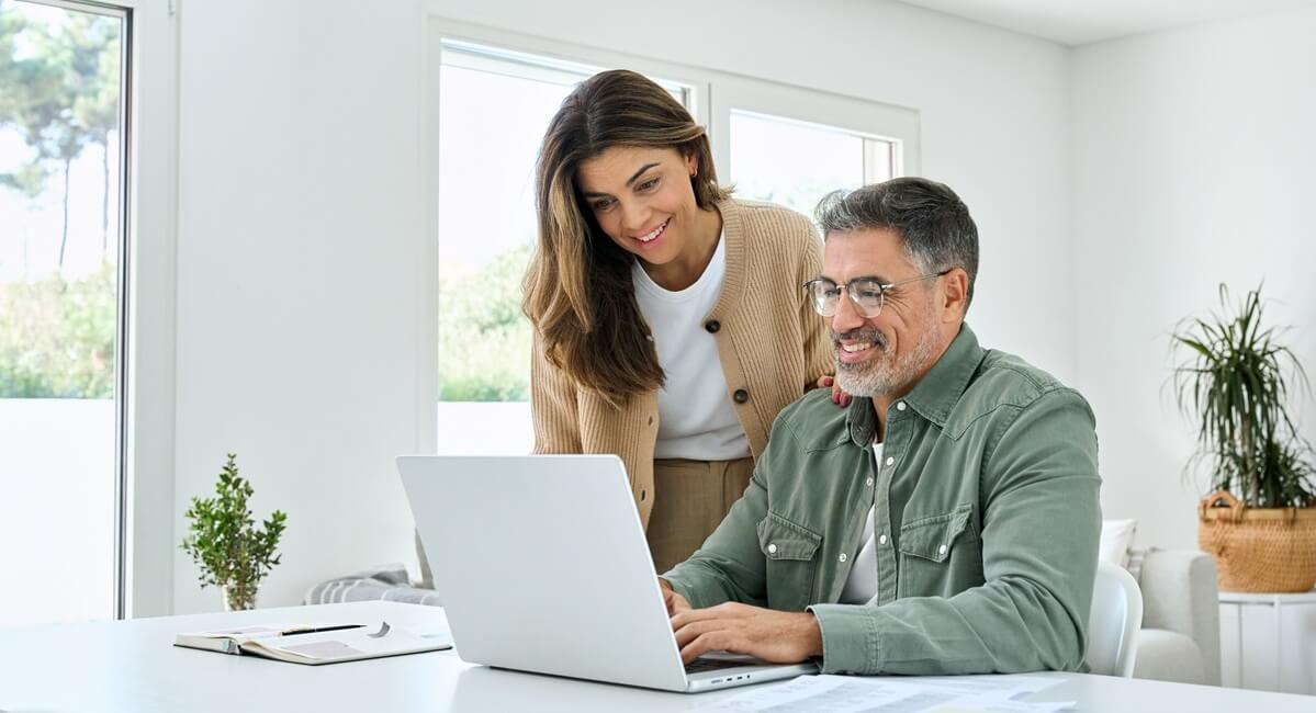 Couple reviews answers to their Affidavit of Support questions in front of a computer