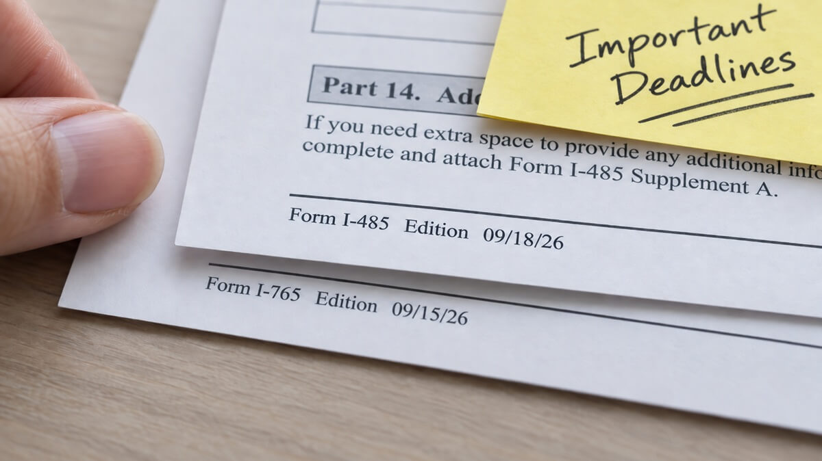 Close-up of edition dates printed in the corner of two USCIS immigration forms